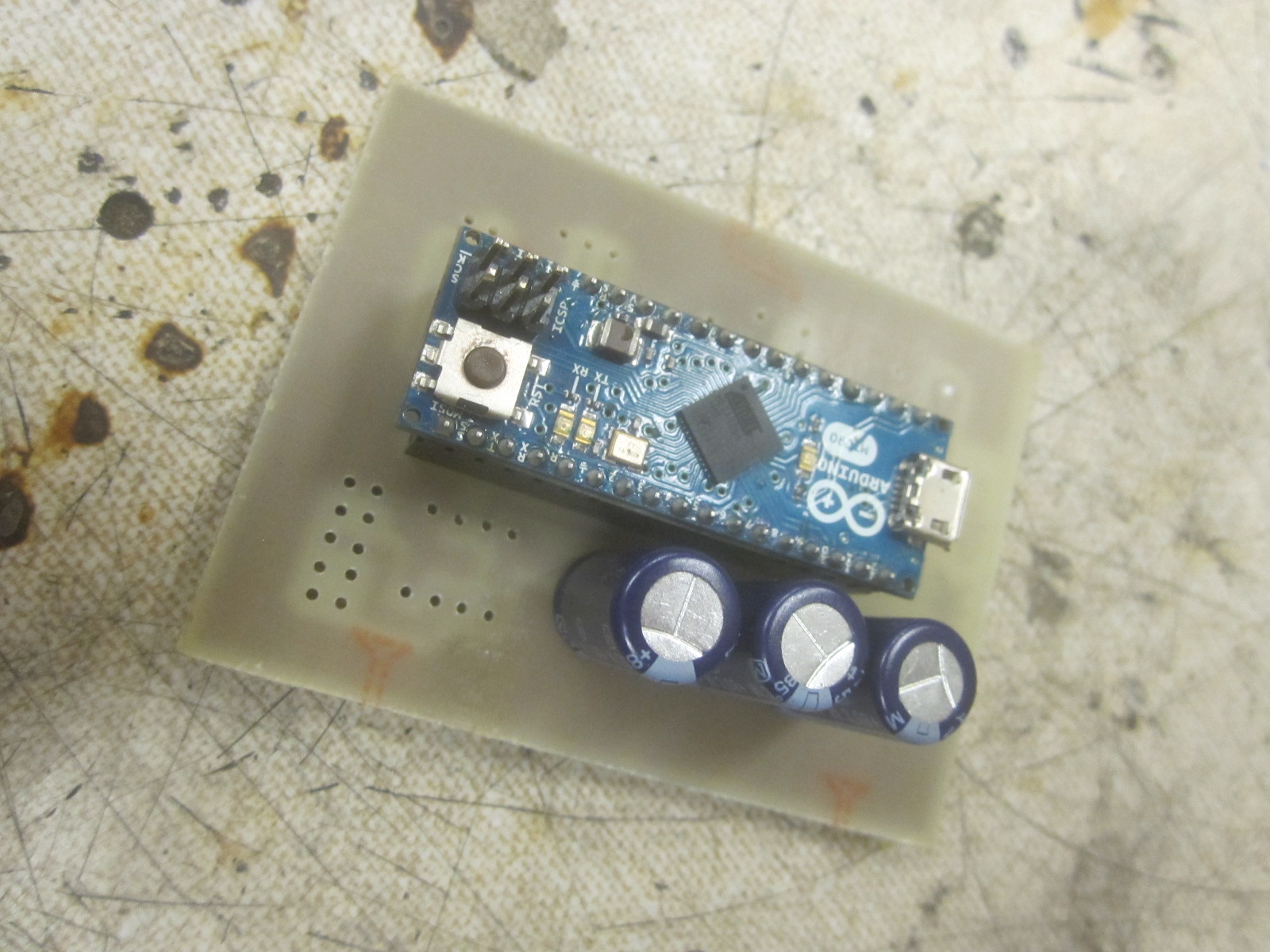 etched board with Arduino and capacitors installed